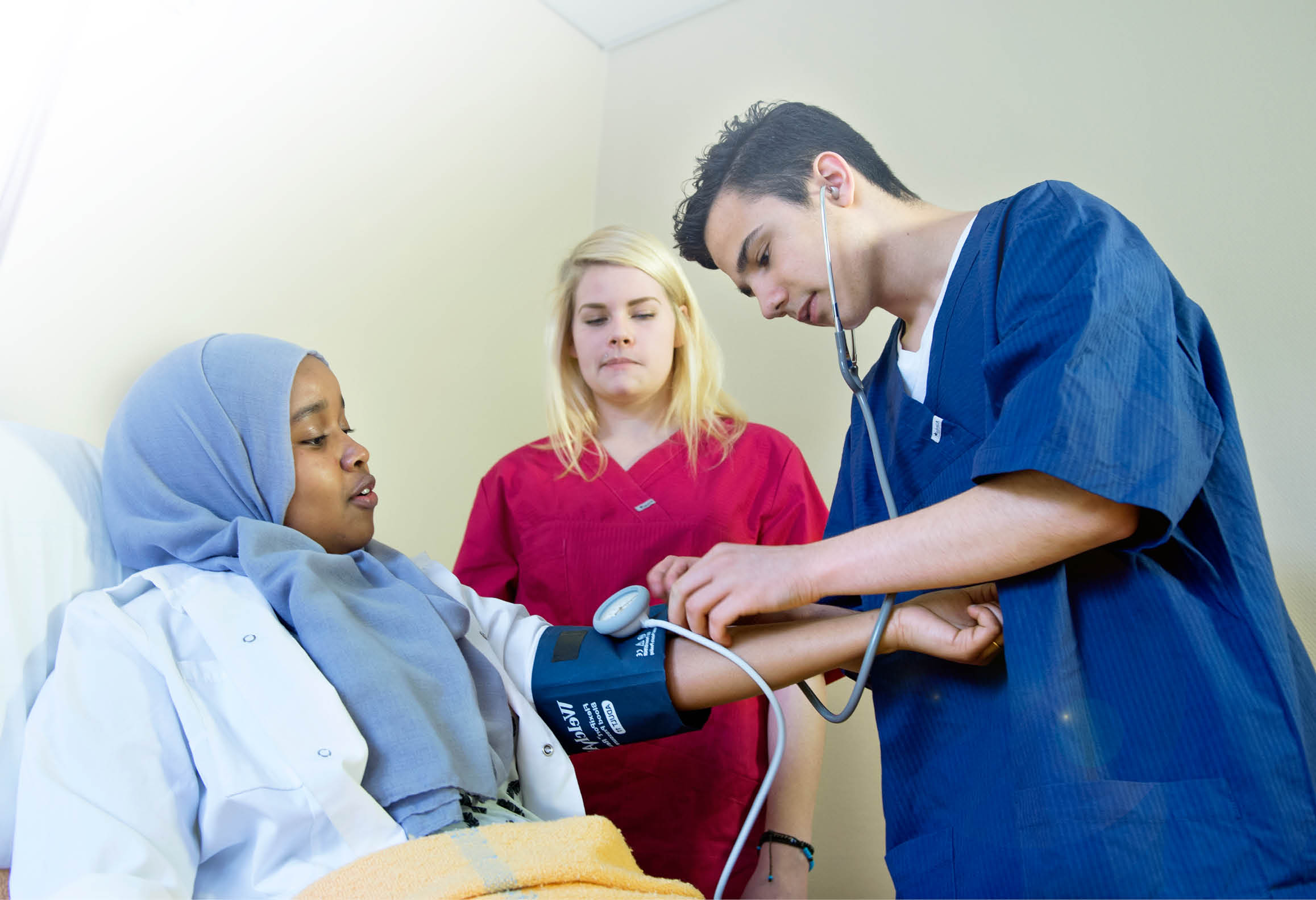 Elever övar sig i att använda blodtrycksmätare